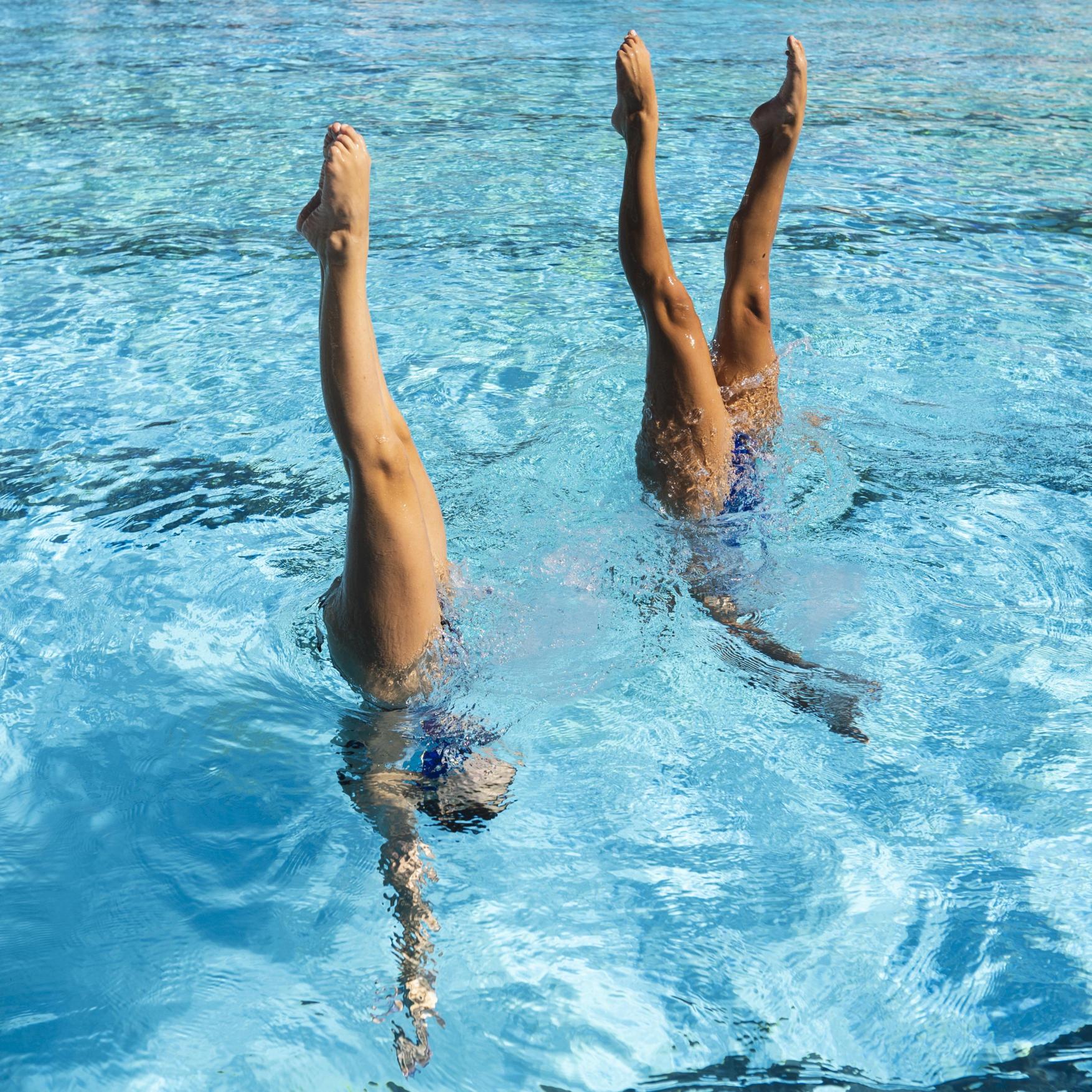 kobiety wykonujące figury akrobatyczne w wodzie